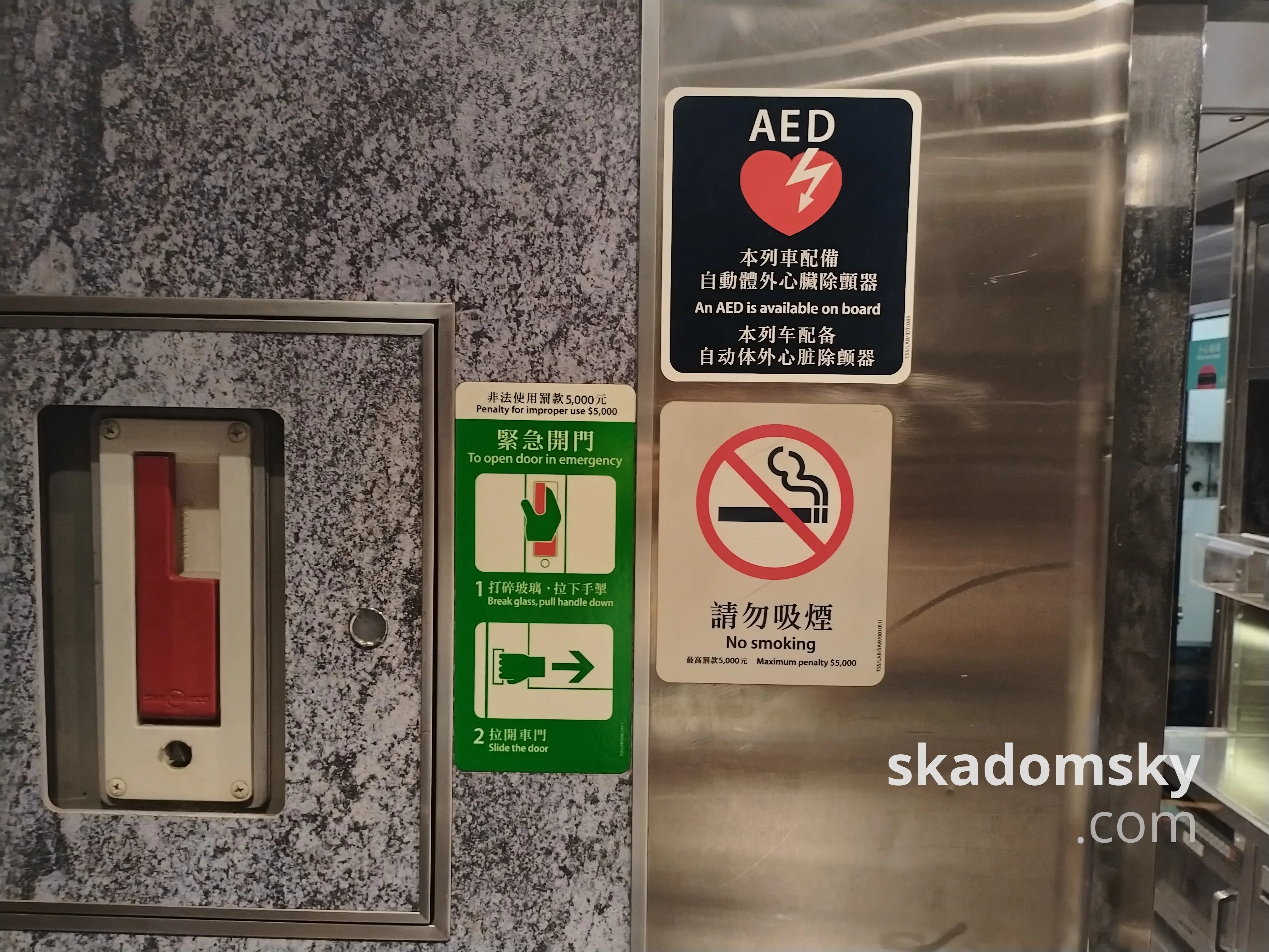 车厢标志:“本列车配备自动体外心脏除颤器”,下方是禁止吸烟的提示,左侧是红色的紧急开门把手。