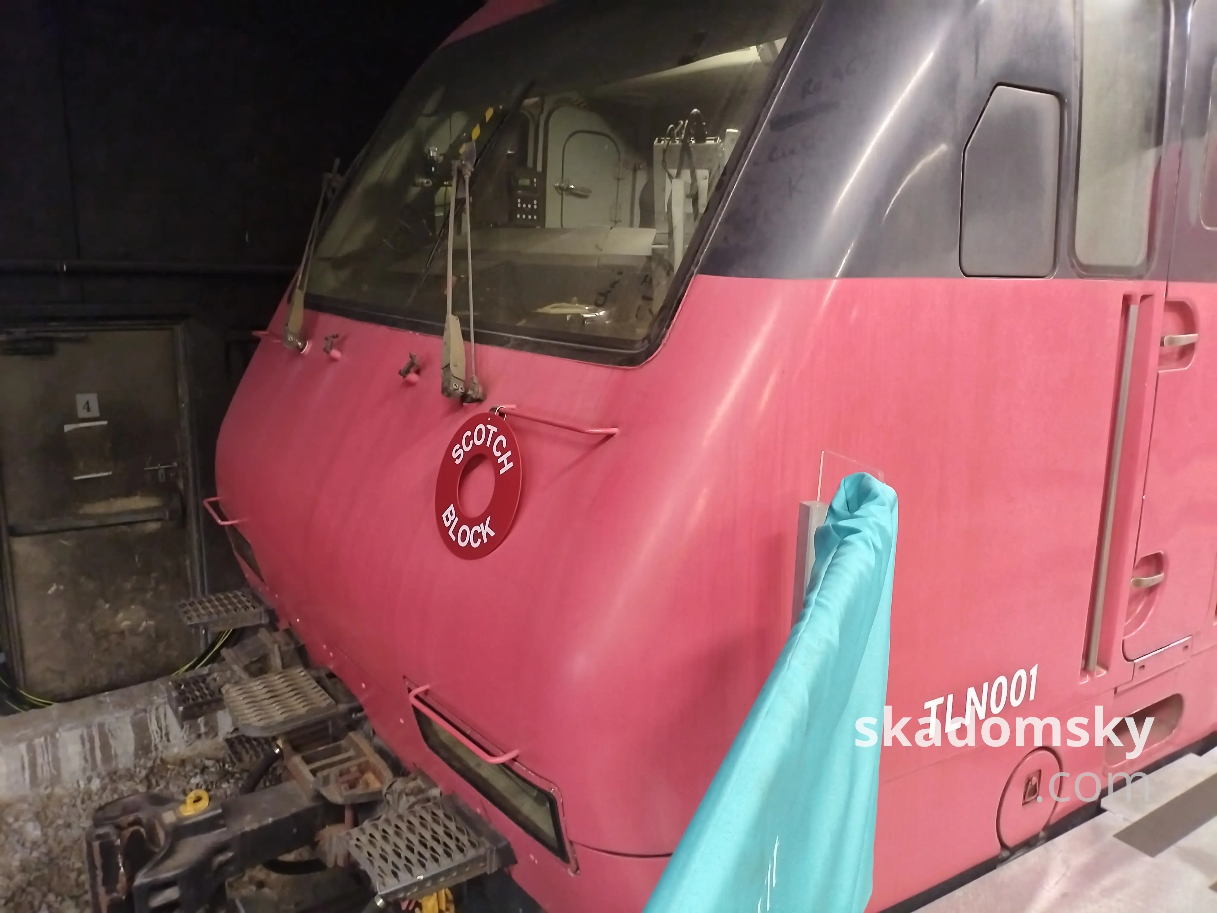 停放在站台边上的编号为TLN001的ktt车头,红头朝外,上挂有SCOTCH BLOCK的红色状态指示牌。