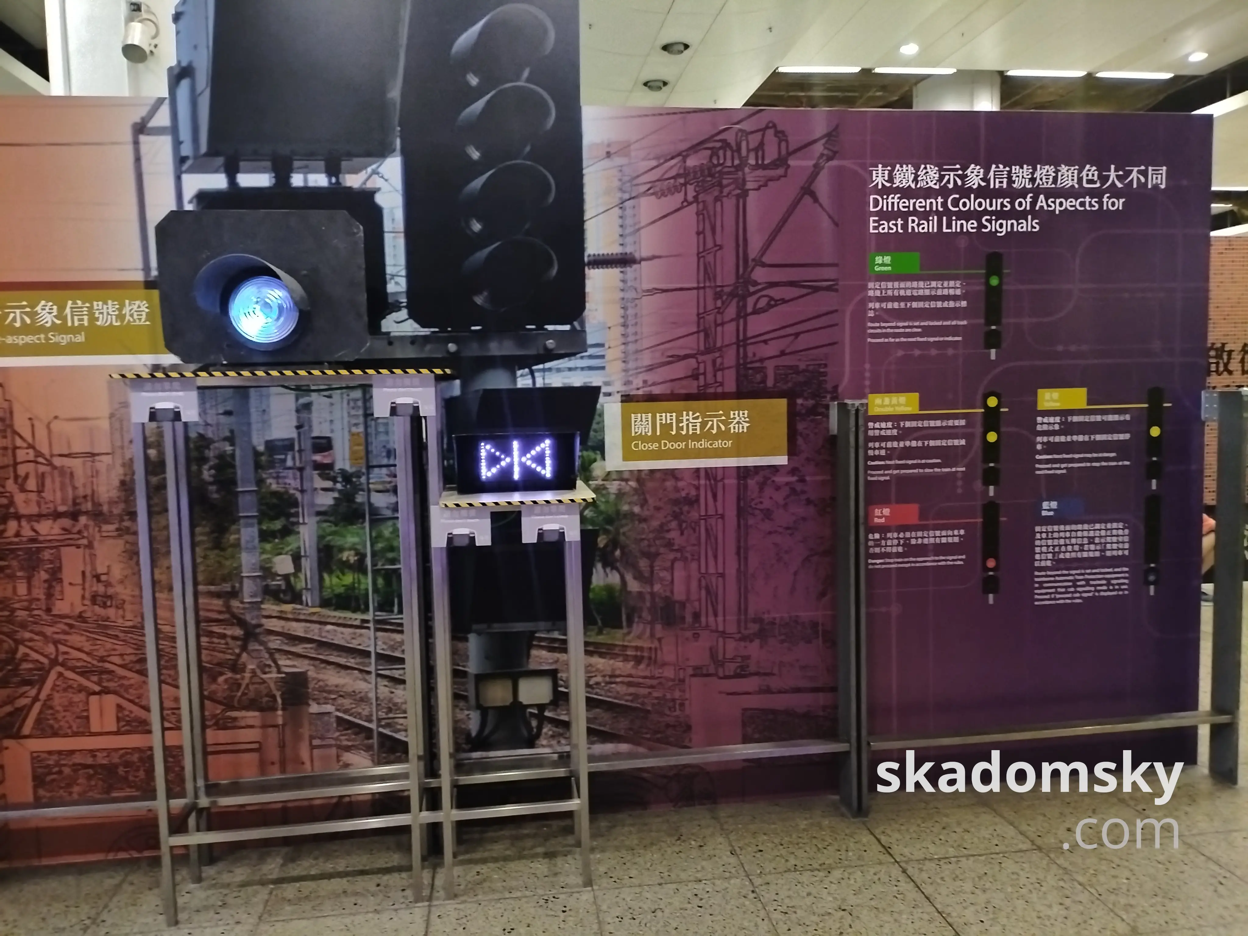 东铁线示象信号灯颜色大不同。展板右侧介绍了四色信号的含义,左侧展示了白色灯光的关门指示器。